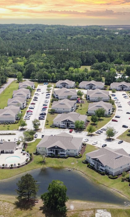 an aerial view of a neighborhood with houses and cars parked in a parking lot at The Pointe Apartment Homes in Mississippi 39553