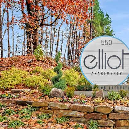 A sign for Elliot Apartments is in front of a road.