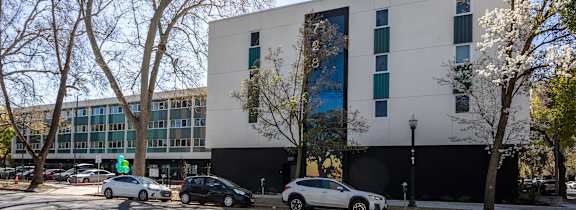a computer generated image of a large office building with cars parked in front of it at THE MOD AT MIDTOWN Apartments, SACRAMENTO,  California