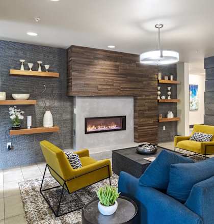 A living room with a fireplace and a blue couch. at Kirkland Crossing Apartments, Kirkland, WA
