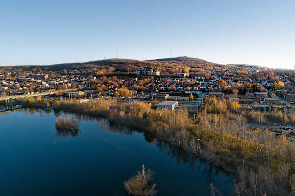 A small town is reflected in the water of a lake.