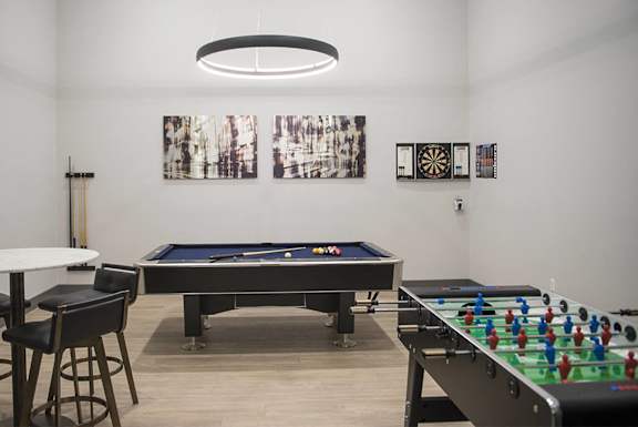 a game room with two pool tables and a foosball