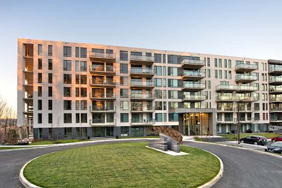 A large apartment building with a grassy area in front.