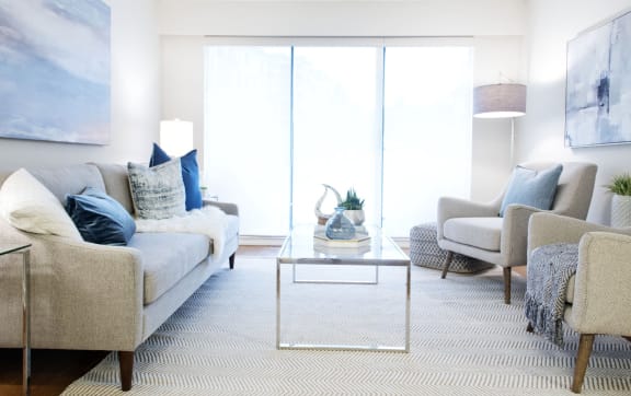 a living room with couches and chairs and a glass coffee table