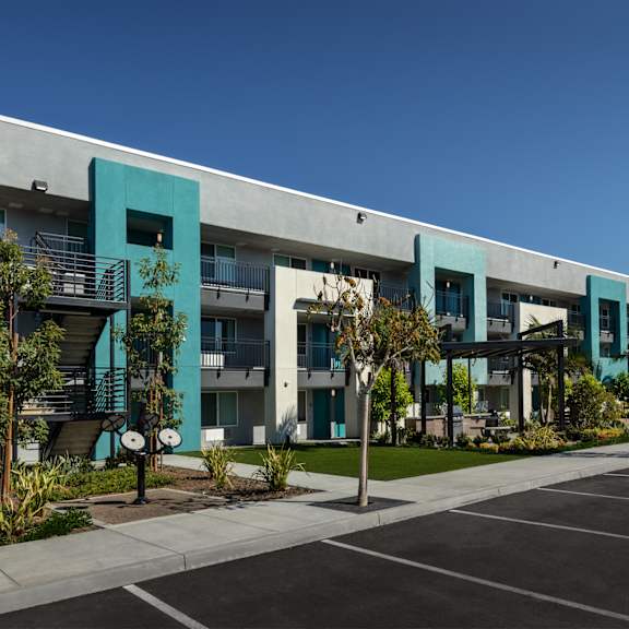 The front of the Mesa Vista Apartments building with a flag flying in the background.
