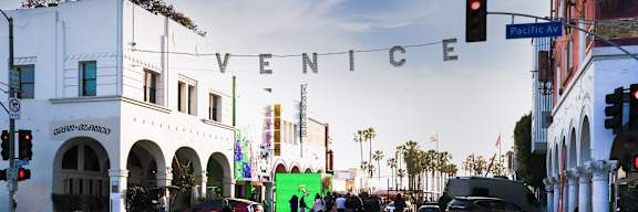A street view of a city with the word "VENICE" written in the sky.