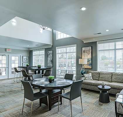 A well-lit living room with a dining table and chairs at Abbey Ridge Apartment Homes, Oxford, 48371
