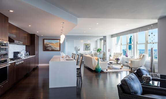 A modern kitchen with dark wood floors and a large island in the middle at Residences Providence, Rhode Island 2903