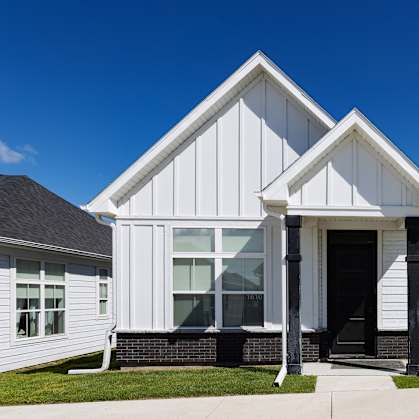 A white house with a black roof and a black door.