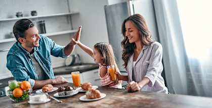 A family is having breakfast together in a kitchen.
