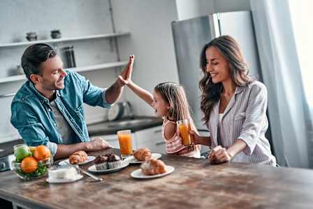 A family is having breakfast together in a kitchen.