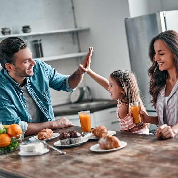 A family is having breakfast together in a kitchen.