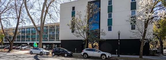 a computer generated image of a large office building with cars parked in front of it at THE MOD AT MIDTOWN Apartments, SACRAMENTO,  California