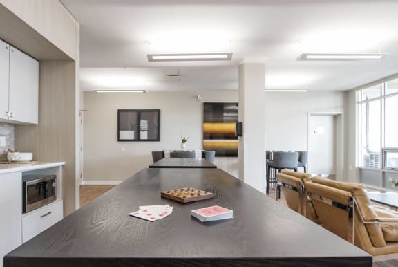 a kitchen and living room with a large black table