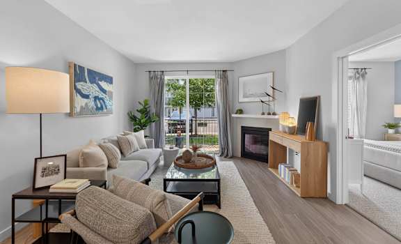 Apartment living room with a gas fireplace and patio door at Madison at Marshfield.