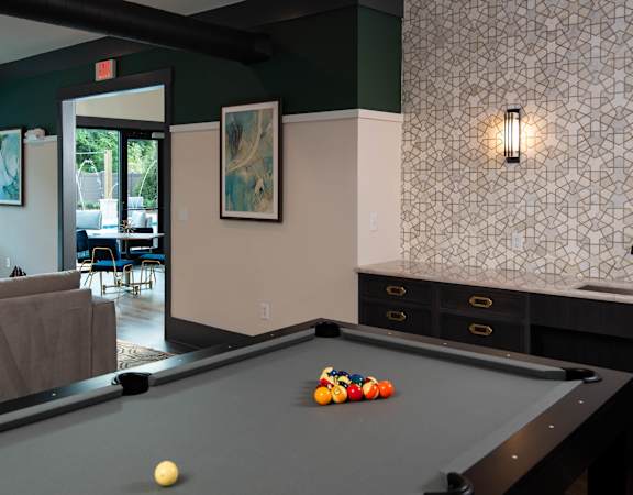 a pool table in a living room with a bar at One Riverside Apartments, Chattanooga, TN, 37403