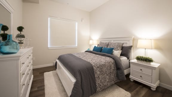 a bedroom with a bed and a dresser and a window