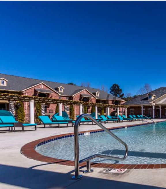 a resort style pool with lounge chairs around it at Arlo Luxury homes Apartments, Little Rock, Arkansas