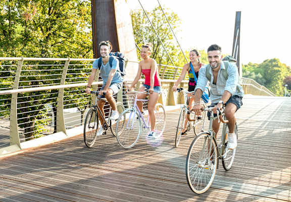 Four people riding bikes on a wooden bridge.at OSM Properties Homes & Apartments, Chico California