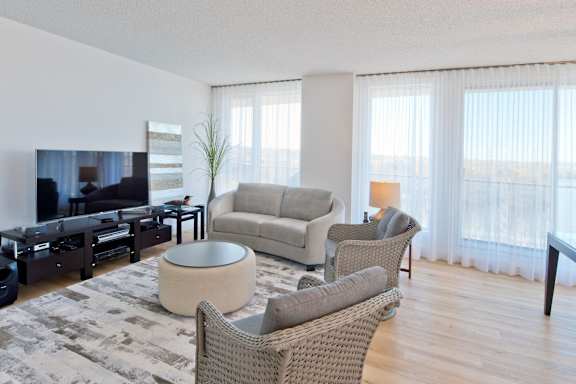 A living room with a large flat screen TV and comfortable seating.