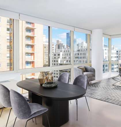 A modern living room with a large table and chairs.