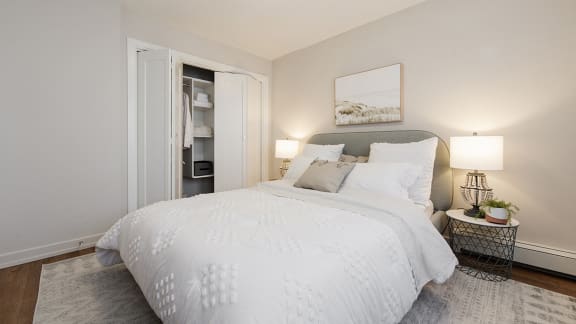 a bedroom with a large white bed and a closet