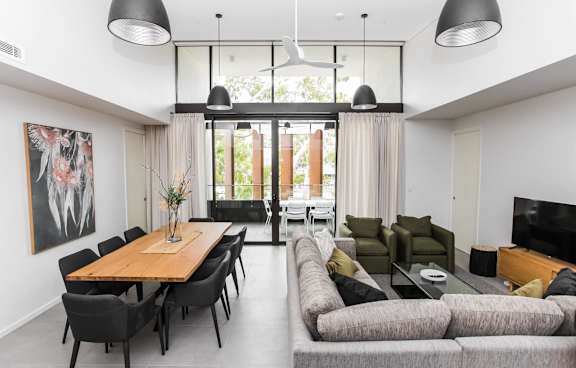 a living room with a green couch and a balcony