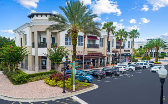 a building with palm trees in front of a parking lot