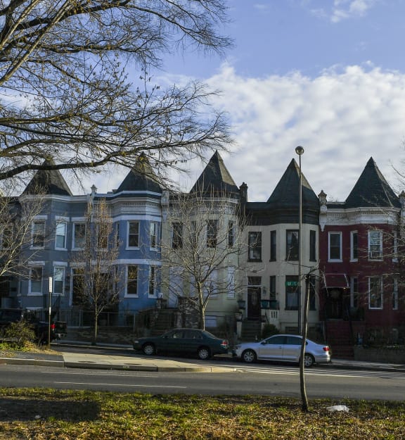 a row of houses on a city street with a street sign