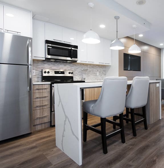 a kitchen and dining room with a white island and stainless steel appliances