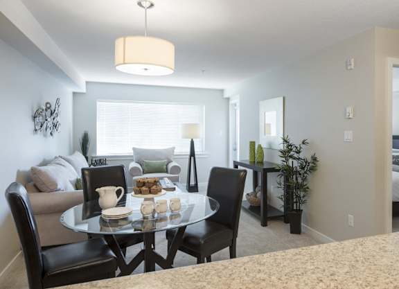 a living room and dining room with a table and chairs