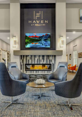 a living room with chairs and a fireplace