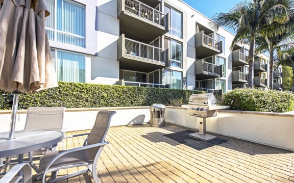 a patio with a grill and a table and chairs in front of an apartment building at Marina Harbor, Marina del Rey, CA, 90292
