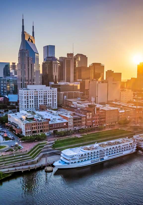A cityscape with a river and a sunset in the background.