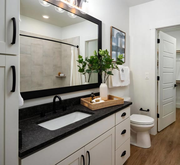 Beautiful full-bathroom with dark countertops and white cabinets at Novel Harpeth Heights