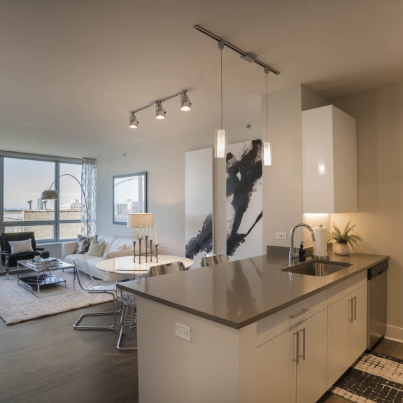 a living room with a kitchen and a couch and a table at The Elle Apartments in West Loop, Chicago, Illinois
