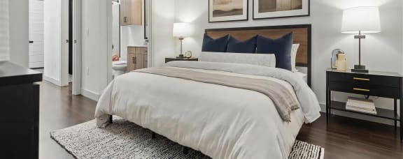 Modern Bedroom Retreat Featuring Hardwood Floors at The Elm at River Park