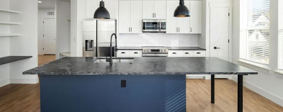 Modern kitchen with large island countertop and tile backsplash at Novel Harpeth Heights