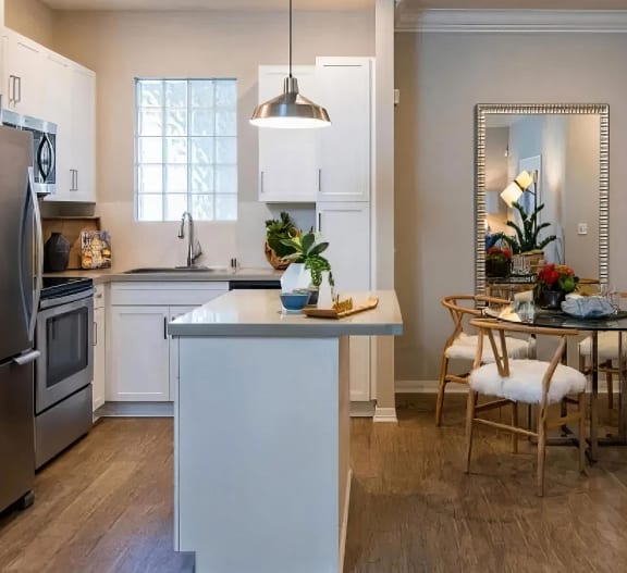 a kitchen and dining room with a table and chairs at Amerige Pointe, Fullerton