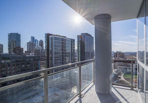 a view of the city from a balcony with a glass railing at The Elle Apartments in West Loop, Chicago
