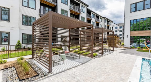 Sophisticated outdoor pool area with cabanas and lounge chairs at Novel Cary