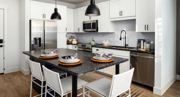 Bright kitchen with island seating and industrial-style lights at Novel Harpeth Heights