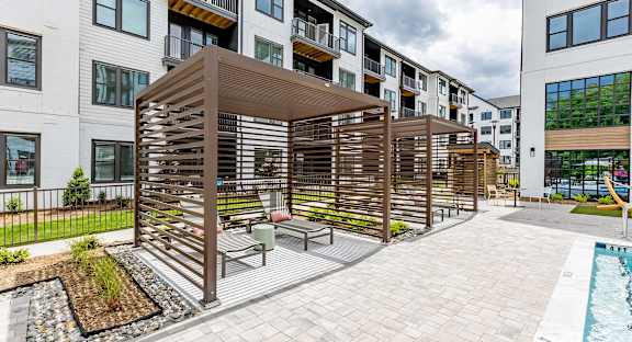 Sophisticated outdoor pool area with cabanas and lounge chairs at Novel Cary