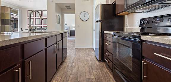 full kitchen with granite counter tops and stainless steel appliances and a clock on the wall