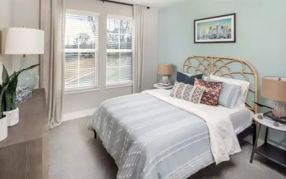 a bedroom with a bed and two windows