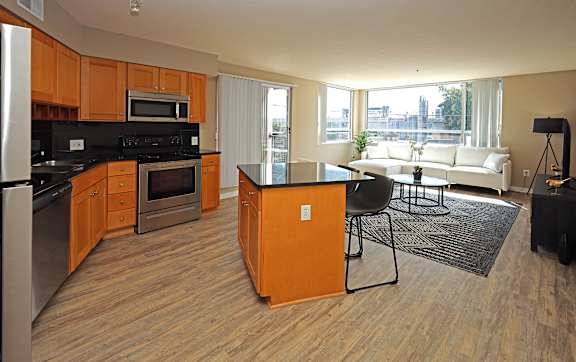 A kitchen with wooden cabinets and a black countertop.