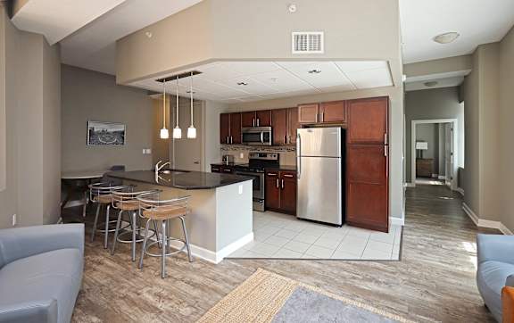 A modern kitchen with a bar area and a refrigerator.