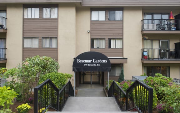 an apartment building with stairs and a sign that reads berkeley gardens