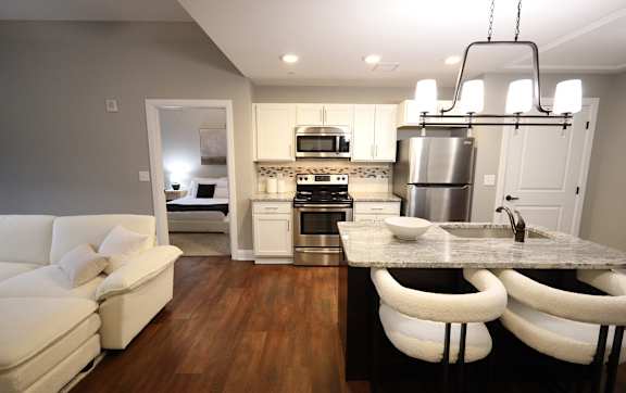 A modern kitchen with a white couch and a marble countertop.