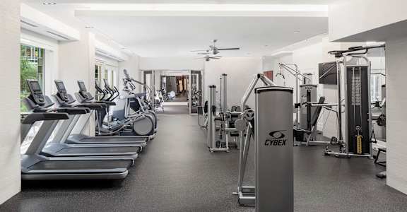 A gym with treadmills, weights, and exercise equipment.